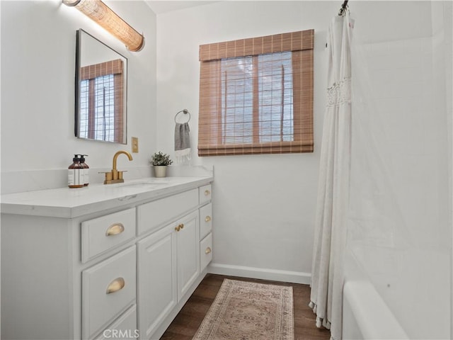 bathroom featuring shower / bath combo with shower curtain, hardwood / wood-style floors, and vanity