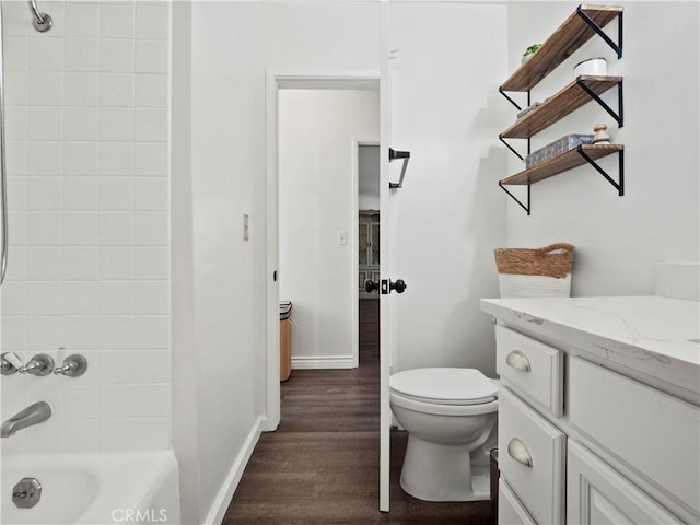 full bathroom featuring tiled shower / bath combo, hardwood / wood-style flooring, toilet, and vanity