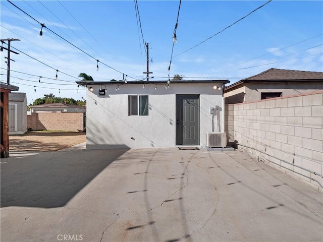 rear view of property with central air condition unit and a patio