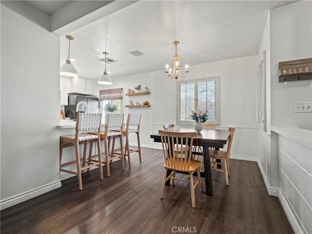 dining area featuring dark wood-type flooring and a notable chandelier