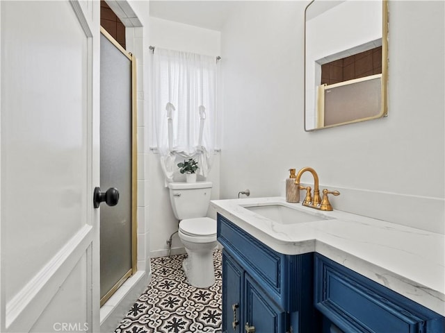 bathroom featuring vanity, a shower with shower door, toilet, and tile patterned flooring