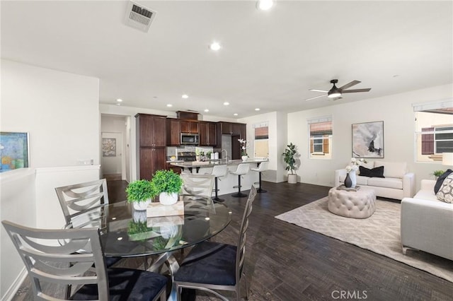 dining area featuring dark wood-type flooring, sink, and ceiling fan