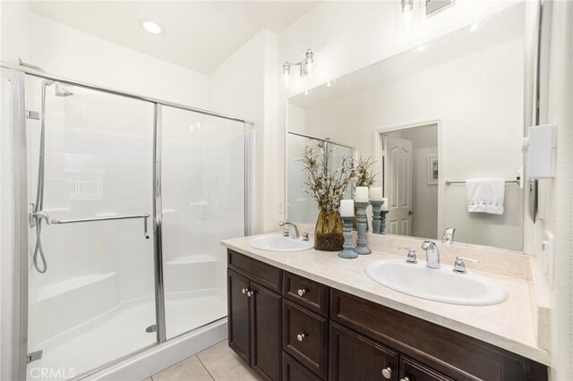 bathroom with tile patterned floors, a shower with shower door, and vanity