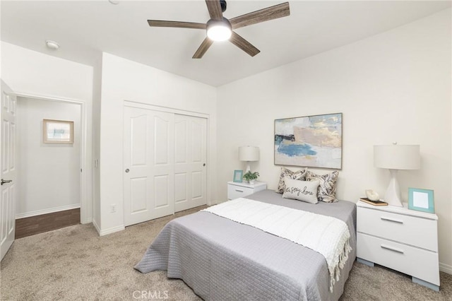 bedroom with light colored carpet, a closet, and ceiling fan