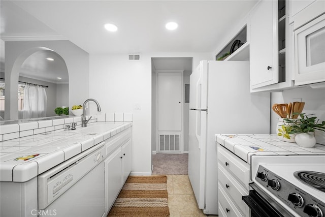 kitchen with sink, white cabinets, tile counters, light tile patterned floors, and white appliances