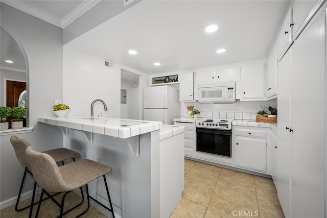 kitchen featuring white cabinetry, white appliances, tile counters, and kitchen peninsula