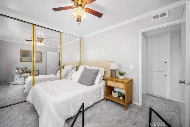 bedroom featuring light carpet, ornamental molding, a closet, and ceiling fan