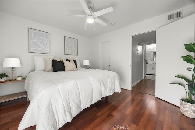 bedroom featuring dark hardwood / wood-style floors, ceiling fan, and ensuite bathroom