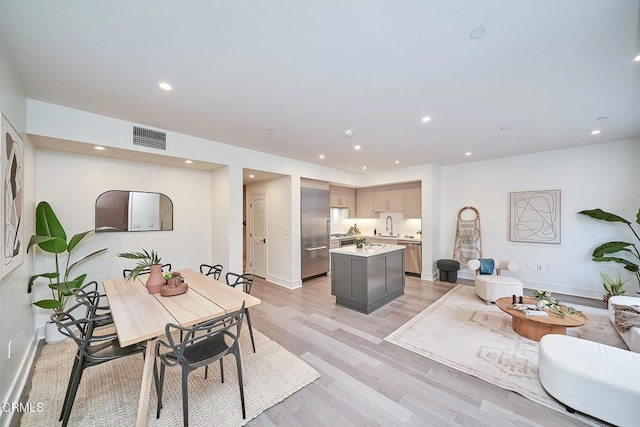 living room featuring sink and light hardwood / wood-style flooring