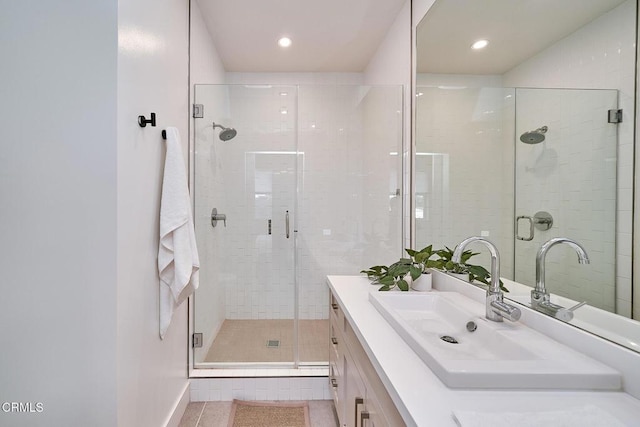 bathroom featuring vanity, a shower with door, and tile patterned flooring