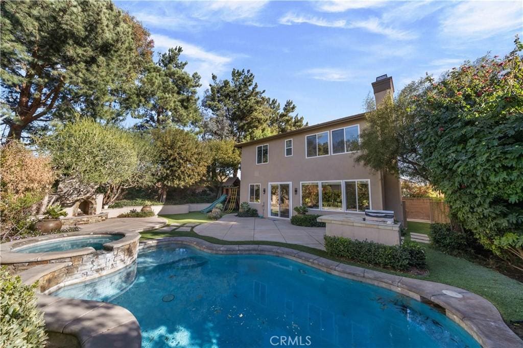 view of swimming pool with an outdoor kitchen, a patio, and an in ground hot tub