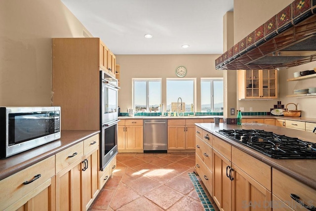 kitchen featuring custom range hood, light tile patterned floors, sink, stainless steel appliances, and light brown cabinets