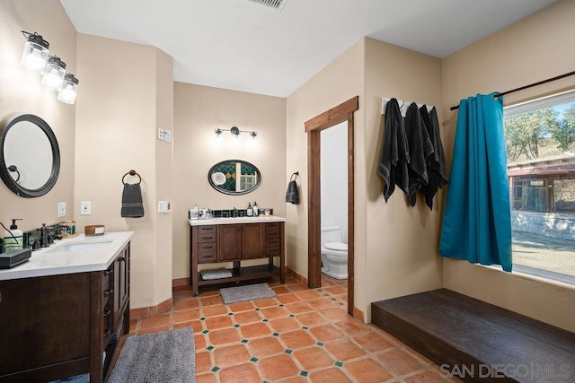 bathroom with toilet, tile patterned flooring, and vanity