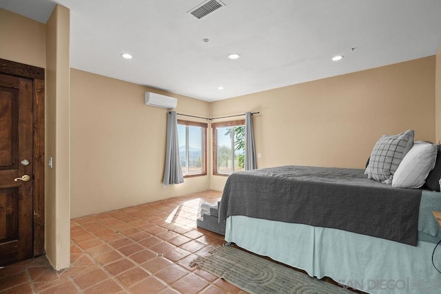 bedroom featuring light tile patterned floors and a wall mounted air conditioner