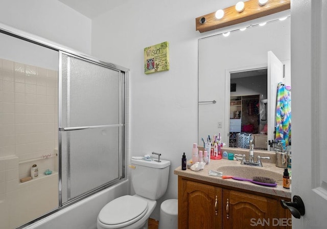 full bathroom featuring toilet, enclosed tub / shower combo, and vanity