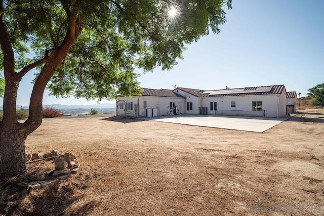 rear view of house with a patio area, cooling unit, and a mountain view