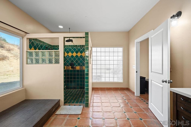 bathroom with vanity, a tile shower, and tile patterned flooring