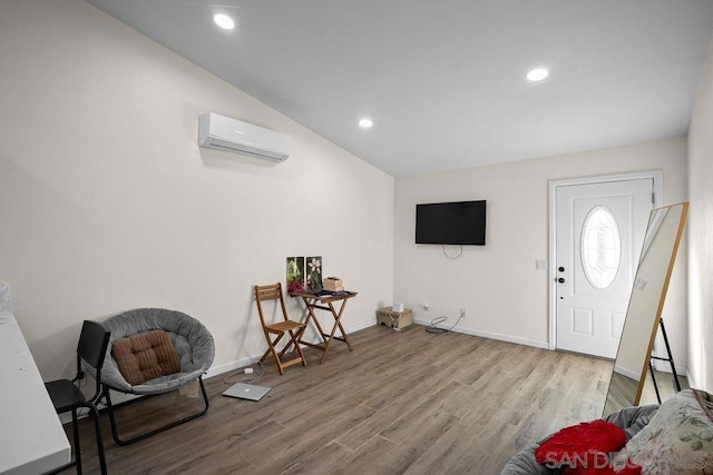 entryway with vaulted ceiling, hardwood / wood-style floors, and a wall unit AC