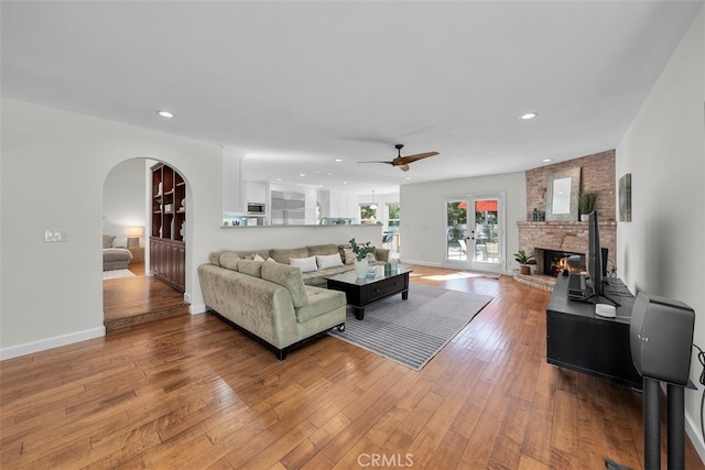 living room with ceiling fan, french doors, and light hardwood / wood-style floors