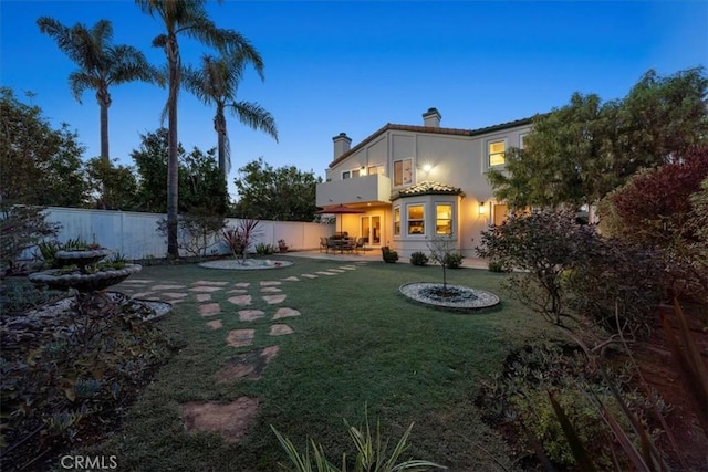 yard at dusk featuring a patio area