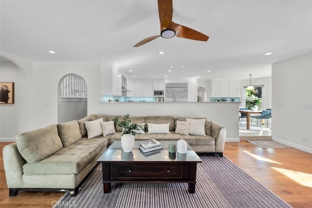 living room featuring light hardwood / wood-style floors and ceiling fan