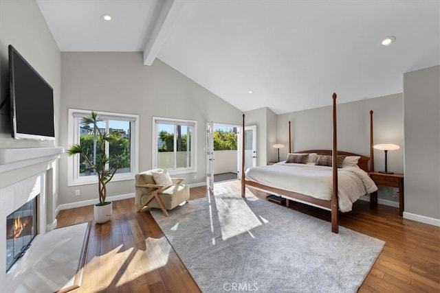 bedroom featuring beamed ceiling, light hardwood / wood-style flooring, a fireplace, and high vaulted ceiling