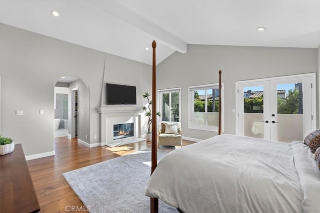 bedroom with wood-type flooring, access to outside, french doors, and vaulted ceiling with beams