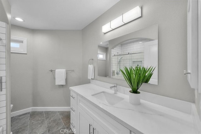 bathroom featuring vanity, toilet, and a tile shower