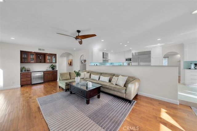 living room with ceiling fan and light hardwood / wood-style floors