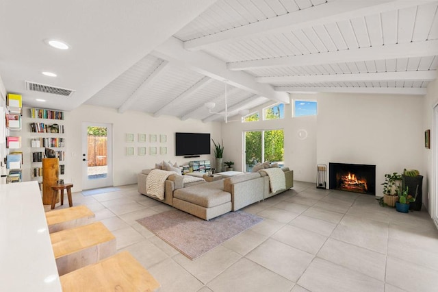 living room featuring a wealth of natural light, light tile patterned floors, and lofted ceiling with beams