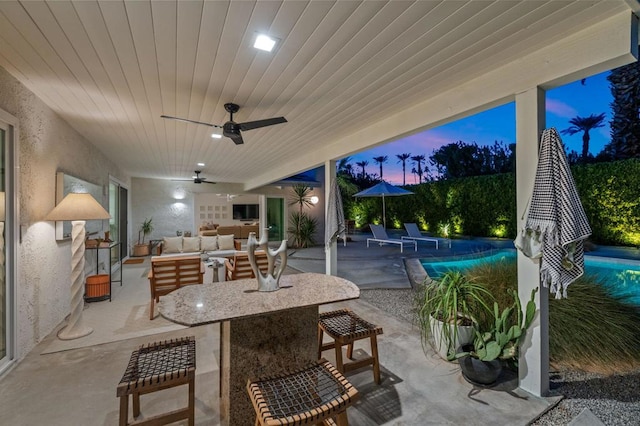 view of patio with exterior bar, outdoor lounge area, and ceiling fan