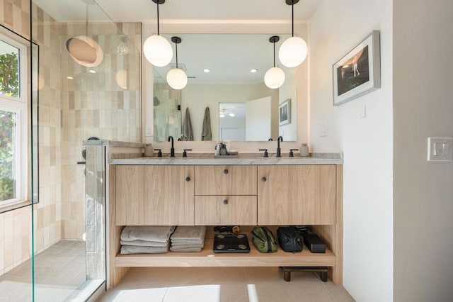 bathroom with a healthy amount of sunlight, tile patterned flooring, walk in shower, and vanity