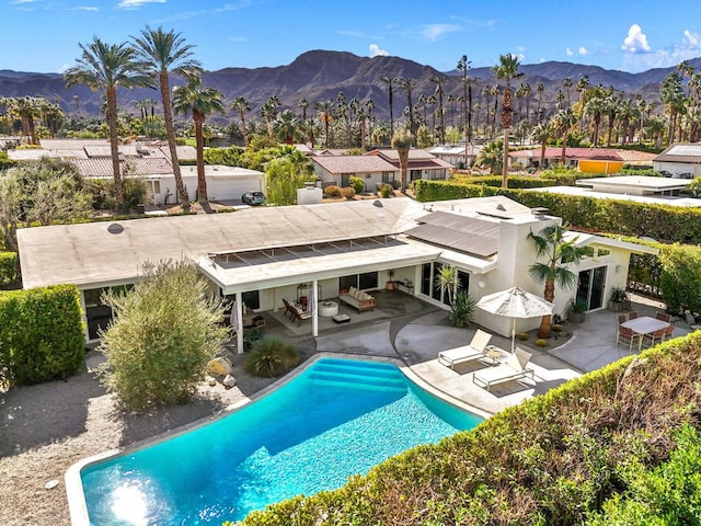 view of swimming pool with a mountain view and a patio