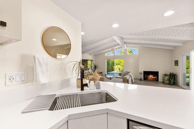 kitchen with plenty of natural light, white cabinetry, and lofted ceiling with beams