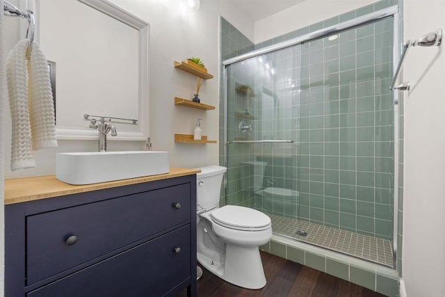 bathroom with hardwood / wood-style flooring, toilet, vanity, and an enclosed shower