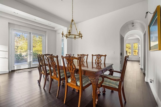 dining room with dark hardwood / wood-style floors and a notable chandelier