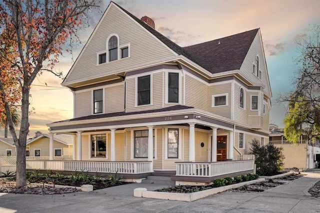 view of front of home with a porch and a shingled roof