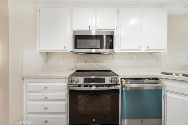 kitchen with white cabinetry, decorative backsplash, light stone countertops, and appliances with stainless steel finishes