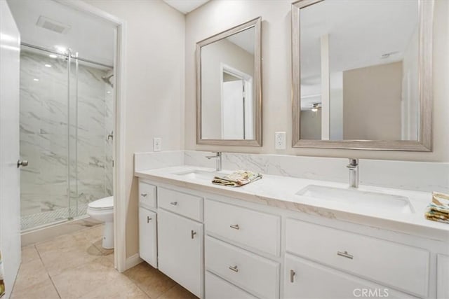 bathroom with vanity, tile patterned flooring, a shower with shower door, and toilet