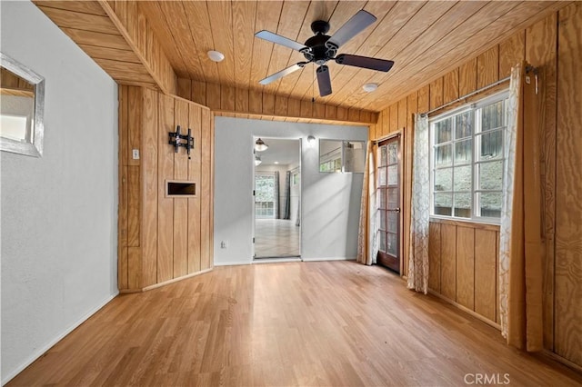 spare room featuring wood ceiling, a wealth of natural light, and wooden walls