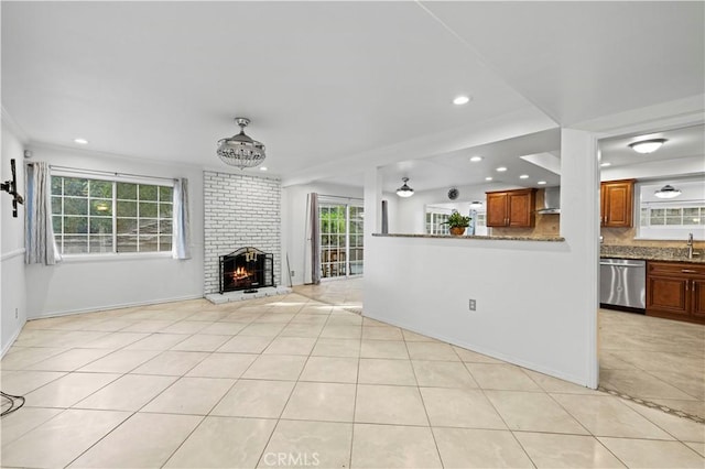 unfurnished living room with a fireplace, sink, and light tile patterned floors