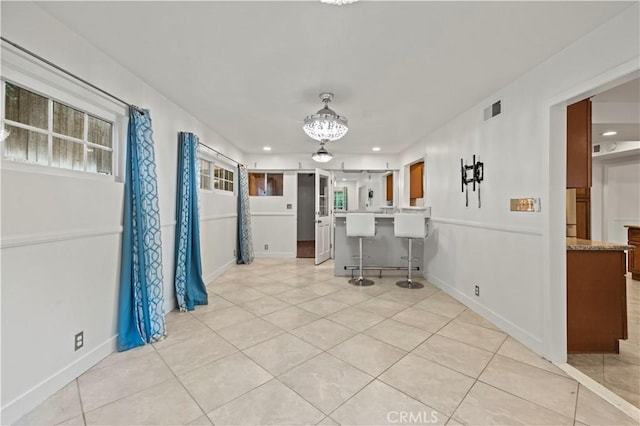 interior space with a kitchen bar and light tile patterned floors