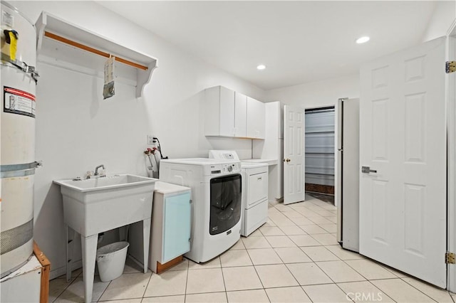 laundry area with washer and clothes dryer, cabinets, and light tile patterned floors