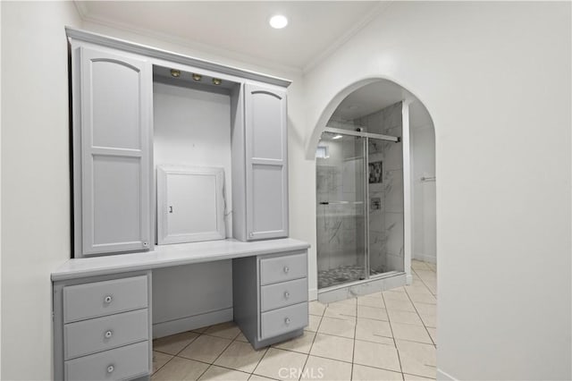 bathroom with crown molding, a shower with door, and tile patterned flooring