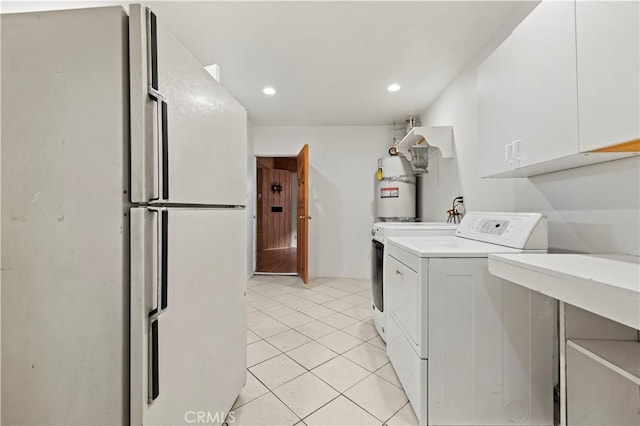 laundry area featuring cabinets, water heater, light tile patterned floors, and washer / dryer