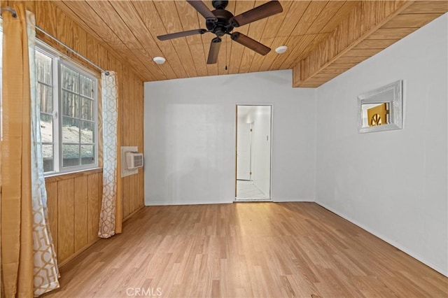 unfurnished room with light wood-type flooring, wood ceiling, and wooden walls