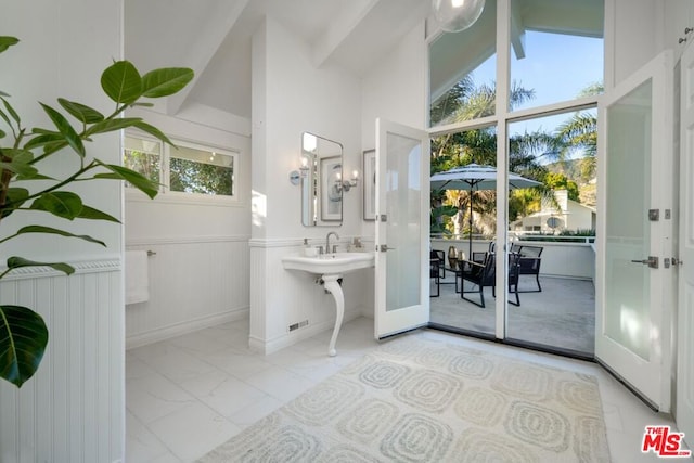 bathroom featuring high vaulted ceiling and french doors