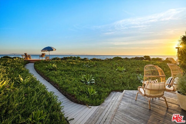 yard at dusk with a deck with water view