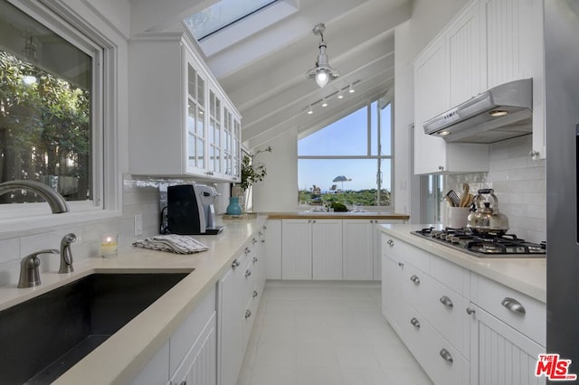 kitchen featuring exhaust hood, white cabinets, and stainless steel gas stovetop