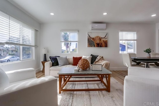 living room featuring light hardwood / wood-style flooring and a wall unit AC